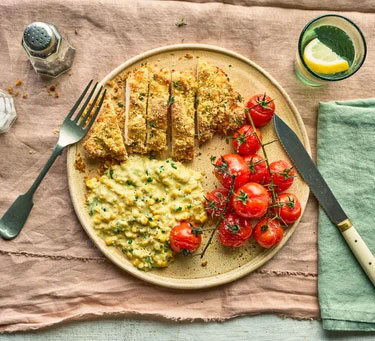 Healthy baked chicken schnitzel with creamed corn